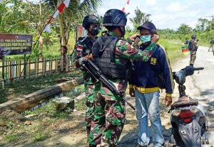 Satgas Yonif 512/QY Bagikan Masker Pada Masyarakat Yang Melintas Di depan Pos Perbatasan